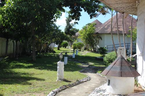 un jardín con un alimentador de aves y una casa en SujungSesang Dive Resort, en Agus