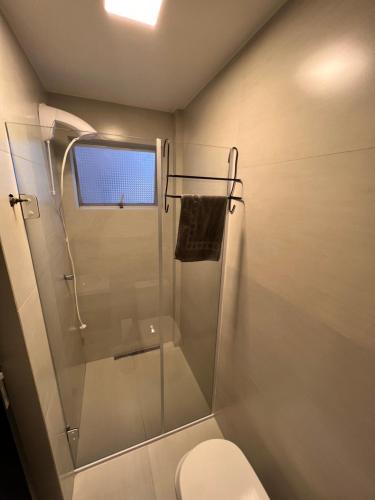 y baño con ducha de cristal y aseo. en Loft Barra norte, en Balneário Camboriú