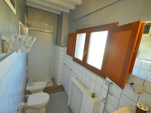 a bathroom with a toilet and a sink and a window at Nice apartment in Gambassi Terme with shared pool in Gambassi Terme