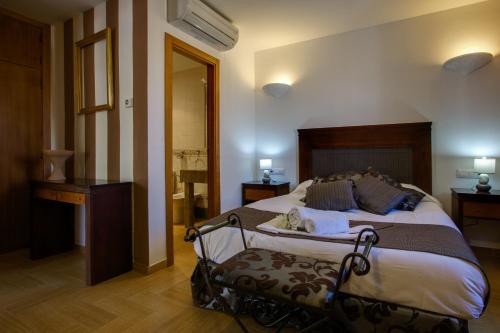 1 dormitorio con 1 cama grande y baño en Hotel Rural Puerto Mágina, en Torres