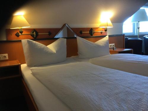 a hotel room with two beds with white pillows at Meeresblick Ferienwohnung in Husum