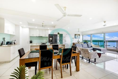 een keuken en een woonkamer met een tafel en stoelen bij ZEN BY THE WATER - Darwin's Premier Ocean View Family Retreat in Darwin