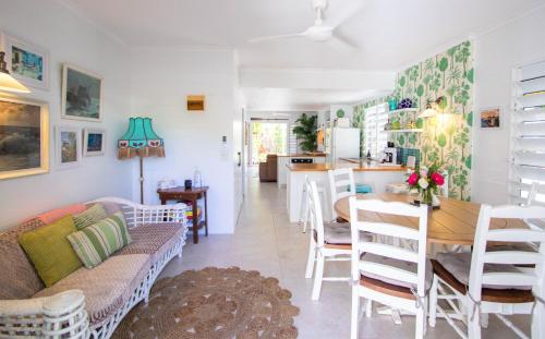a living room and kitchen with a table and chairs at Pandanus Cottage in Port Douglas