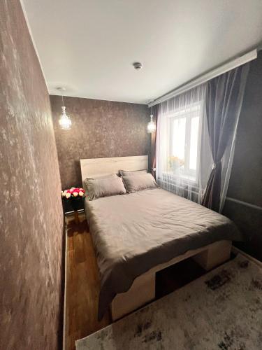 a small bedroom with a bed with a window at Sport Hotel Terra in Ustʼ-Kamenogorsk