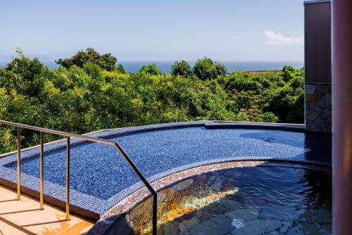 a swimming pool on the side of a house at KAMENOI HOTEL Izukogen in Ito