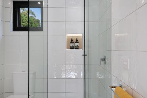 een badkamer met een douche en 2 flessen bij Timboon Tiny Homes in Timboon