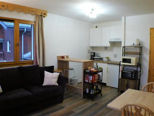 un salon avec un canapé et une cuisine dans l'établissement Charmant 2 pièces cabine avec parking et équipement modern à Samoëns - FR-1-629-121, à Samoëns