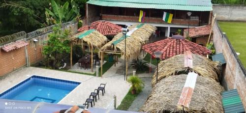 einen Blick über das Resort mit Pool und Sonnenschirmen in der Unterkunft El Buen Sazon Valluno 
