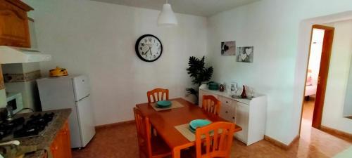 cocina con mesa y reloj en la pared en Casa Nela. Rural y acogedora en Las Puntas El Hierro en Frontera