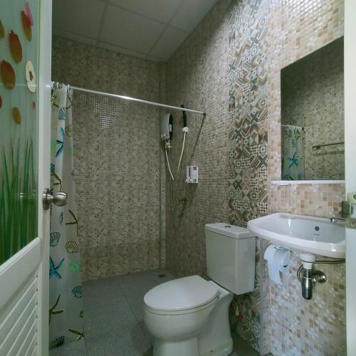 a bathroom with a toilet and a sink at Davy Cottage Phuket in Thalang