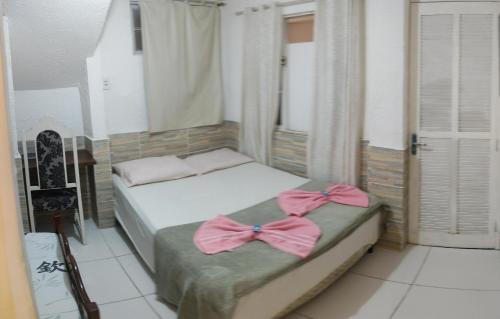 a bedroom with two beds with bows on them at Pousada nascente do sol in Macaé