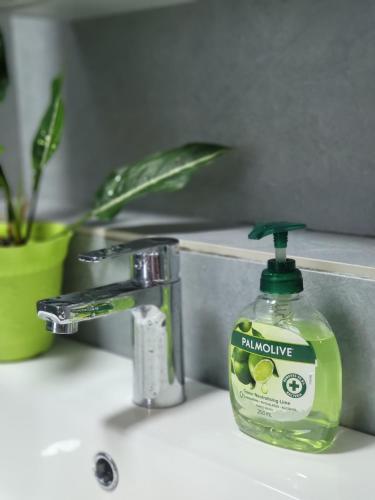 a bottle of laundry detergent sitting on a bathroom sink at Kota Kinabalu Jesselton Quay Seaview with washing machine in Kota Kinabalu