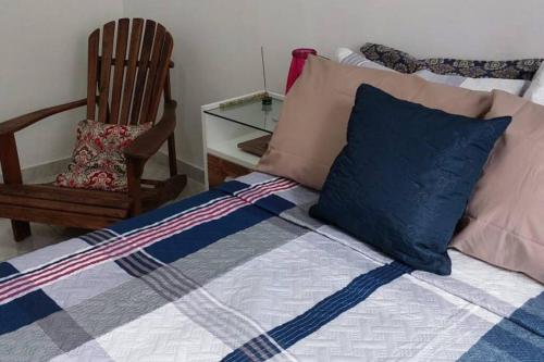 1 cama con almohadas, silla y mesa en Casa em Vila Isabel, en Río de Janeiro