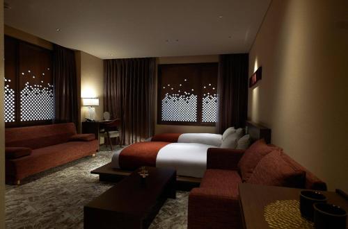 a hotel room with a bed and a couch at Minn Kanazawa in Kanazawa