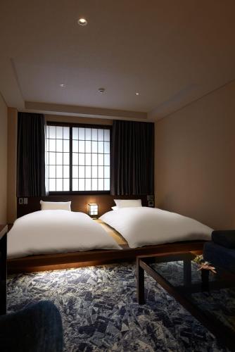 a bedroom with a large bed and a window at Minn Kanazawa in Kanazawa