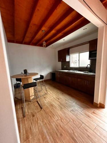 a kitchen with a table and chairs in a room at Departamento rústico in Rosarito
