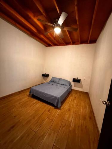 a bedroom with a bed and a ceiling fan at Departamento rústico in Rosarito