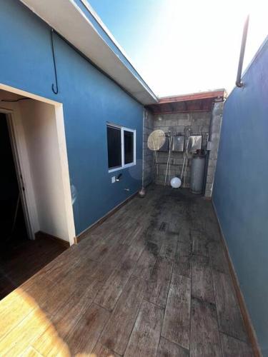 an empty room with a blue wall and wooden floors at Departamento rústico in Rosarito