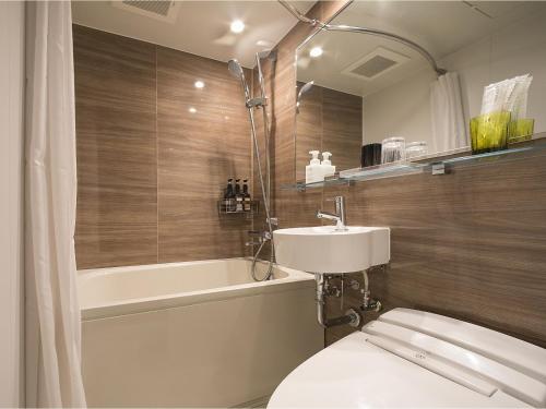 een badkamer met een toilet, een wastafel en een bad bij Hotel Oriental Express Osaka Shinsaibashi in Osaka