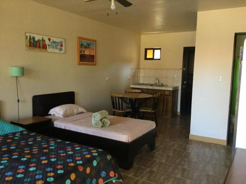 La GaritaにあるVillas el Cenizaroのベッド2台とキッチンが備わるホテルルームです。