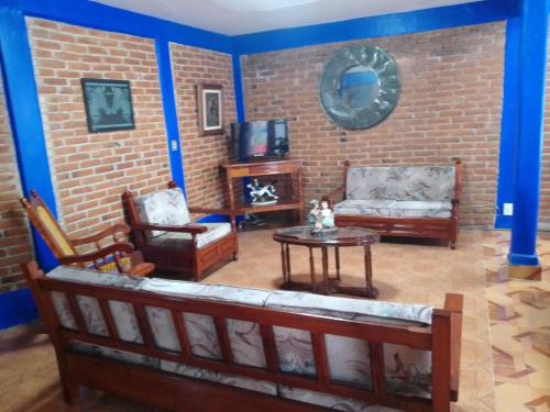 a living room filled with furniture and a brick wall at COYOACAN DEPARTAMENTO TIPO COLONIAL in Mexico City