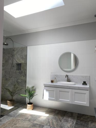 a bathroom with a sink and a mirror at Bloomfield Manor in Bowral