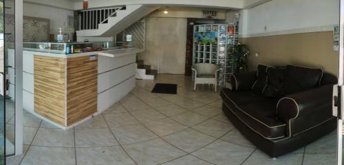 a living room with a couch and a counter at Pousada nascente do sol in Macaé
