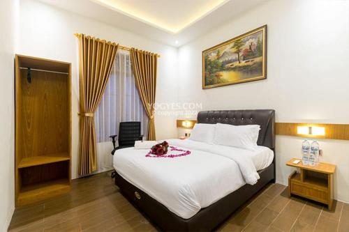 a bedroom with a large bed with a stuffed animal on it at KESATRIYAN JOGJA GUEST HOUSE in Yogyakarta