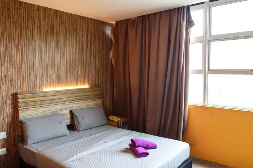 a bedroom with a bed with a purple stuffed animal on it at Classical Boutique Hotel in Puchong