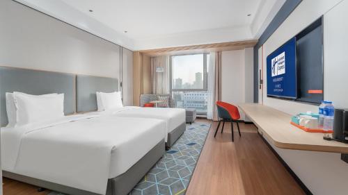 Pokój hotelowy z dużym białym łóżkiem i biurkiem w obiekcie Holiday Inn Express Lanzhou Jianlan, an IHG Hotel w mieście Lanzhou