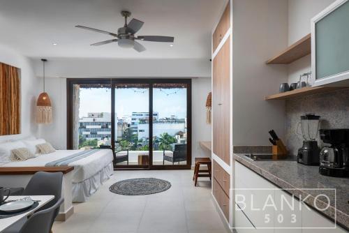 um quarto de hotel com uma cama e uma cozinha com vista em 5th Av New Luxury Condo - Ocean View em Playa del Carmen