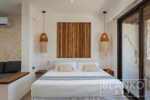 1 dormitorio con 1 cama y 2 luces colgantes en 5th Av New Luxury Condo - Ocean View - Free Airport Pick up - 5 Nights, en Playa del Carmen