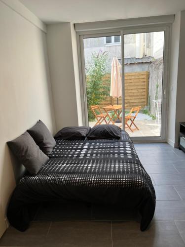 a bed in a room with a large window at Logia 2 in Ploërmel