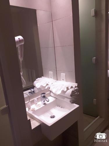 a bathroom with a sink and a mirror at Jandira Premiêr Hotel in Jandira