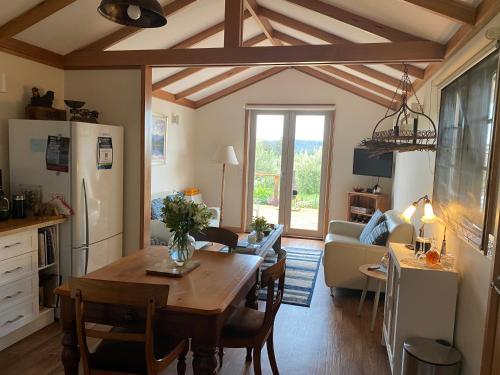 a kitchen and living room with a table and a refrigerator at Wanderers Cottage in Woodbridge