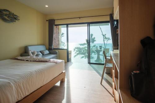 a bedroom with a bed and a sliding glass door at Cliff Lanta Suite-Koh Lanta Krabi in Ko Lanta