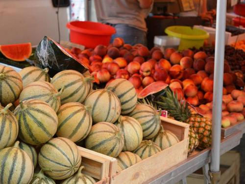 une exposition de fruits et légumes sur un marché dans l'établissement Appartement cosy avec terrasse et parking, à 2 pas de la plage de Saint-Clair - Ménage inclus - FR-1-251-12, au Lavandou