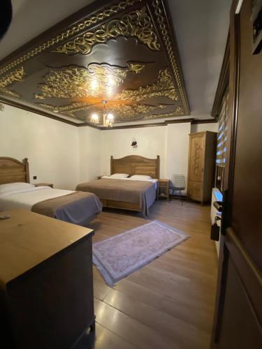 a bedroom with two beds and a large ceiling at Ziyagil Konağı in Amasya