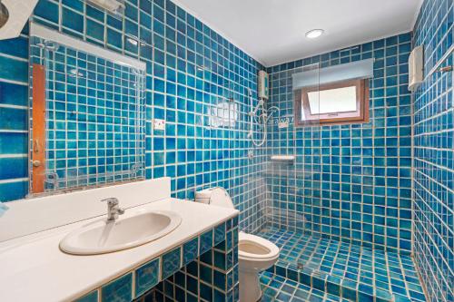 baño de azulejos azules con lavabo y aseo en Chill Inn Lipa Noi Hostel and Beach Cafe, en Koh Samui 