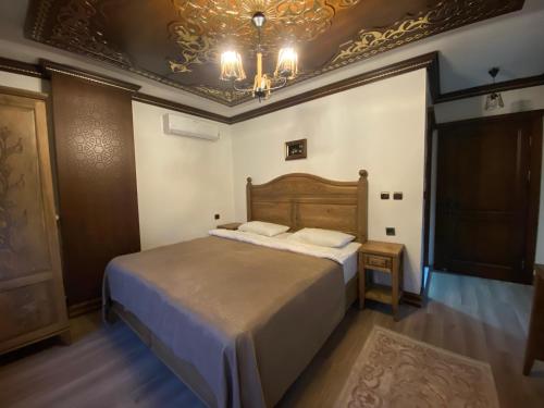 a bedroom with a bed and a chandelier at Ziyagil Konağı in Amasya