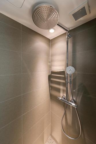 a shower with a shower head in a bathroom at THE GENERAL KYOTO Bukkouji Shinmachi in Kyoto