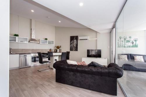 a living room with a couch and a kitchen at Waverley apartment A-two bedrooms wifi available in Perth