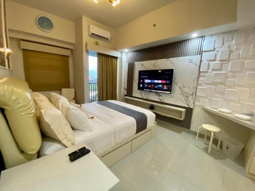 a bedroom with a large bed with a flat screen tv at Parkland Avenue Serpong BSD - Locca cafe in Babakan