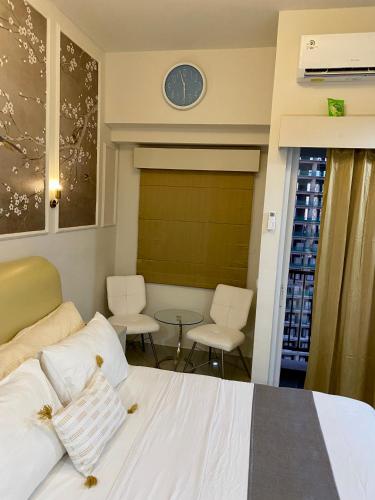 a bedroom with a bed and a clock on the wall at Parkland Avenue Serpong BSD - Locca cafe in Babakan