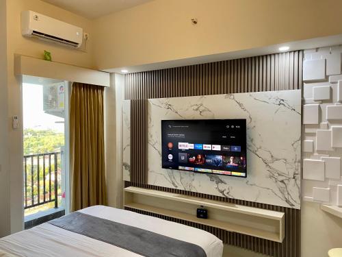 a bedroom with a tv on a wall at Parkland Avenue Serpong BSD by Owner in Babakan
