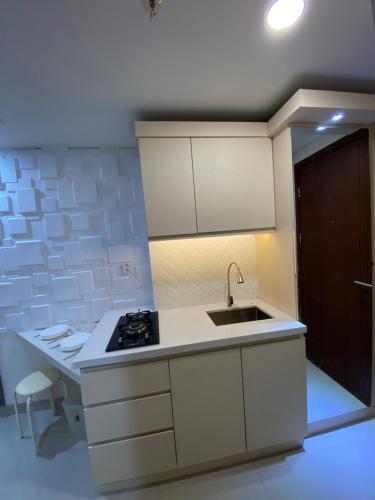 a small kitchen with a sink and a stove at Parkland Avenue Serpong BSD - Locca cafe in Babakan