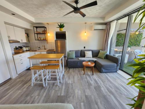 Una cocina y una sala de estar con un sofá y una mesa. en Stylish Studio Apartment, Holiday Resort, With View, Pool, Spa , Sauna, en Gold Coast