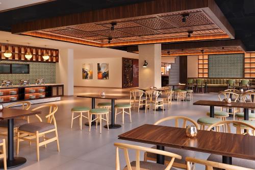 a restaurant with wooden tables and chairs at ARTOTEL Batam in Nagoya