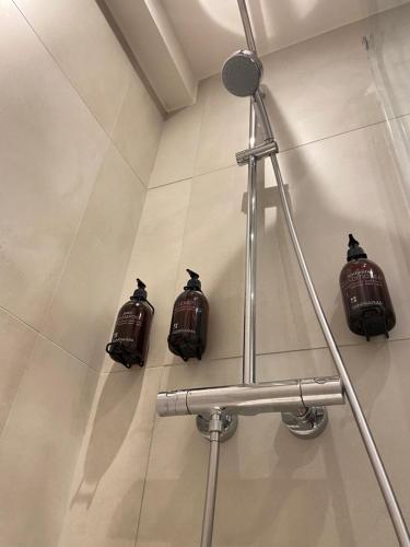 a bathroom with three brown pots on the wall at Studio Delfien in Oostduinkerke