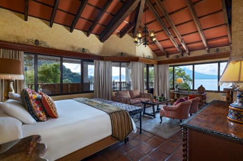 a bedroom with a large bed and a living room at Hotel Atitlan in Panajachel